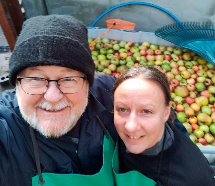 Man and wife pose for a picture after washing apples