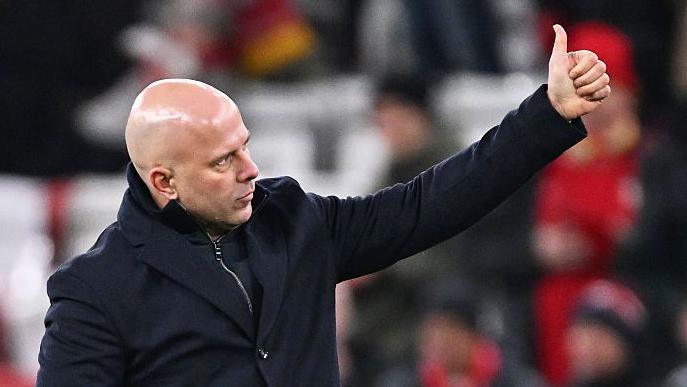 Arne Slot gives a thumbs-up to the crowd at Anfield