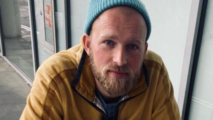 A close up shot of Joshua Fenton wearing a beanie hat