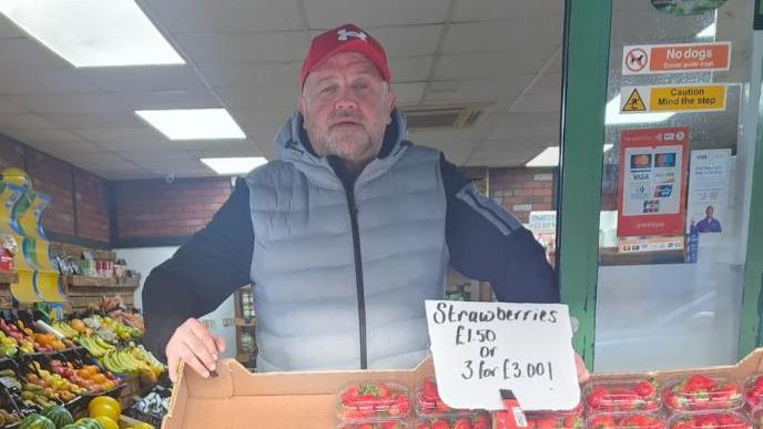 A man in front of strawberries 