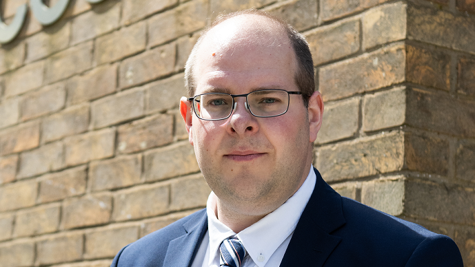 A picture of Conservative Hertfordshire Police and Crime Commissioner Jonathan Ash-Edwards wearing a blue suit jacket with a blue and white striped tie.