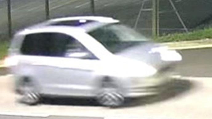 A blurry photo of a silver car, taken from what appears to be CCTV footage