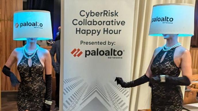 Two women in dresses pose with Palo Alto-branded lampshades covering their faces