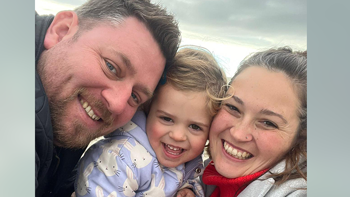 Leo, on the left, Alara in middle and Zoe, on the right of Alara. They are huddled together smiling at the camera for a selfie 