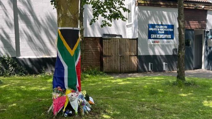 Flowers left by a tree at Ickleford Sports & Recreation Club on Chambers Lane