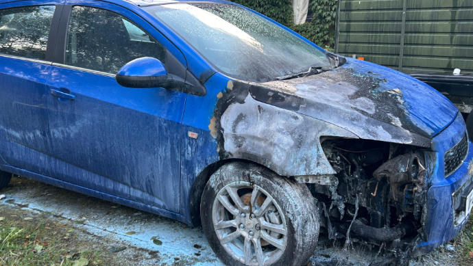 Shows a blue burnt-out car