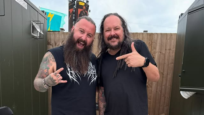 Two long-haired bearded men posing for a photo backstage