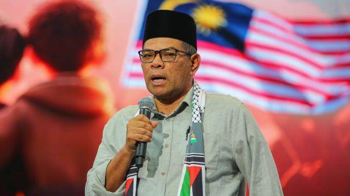 Saifuddin Nasution Ismail, holding a microphone, speaking at an event