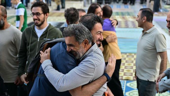 Groups of men embracing one another to celebrate Eid