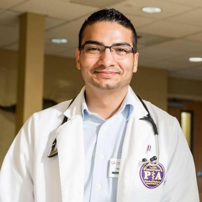 Simon Mendoza Moreno, in white doctor's coat and wearing a stethoscope