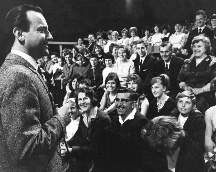 Compere David Jacobs talking to the audience in Studio 2, Television Centre, during the warm up before the live showing of Juke Box Jury. 01/01/1964