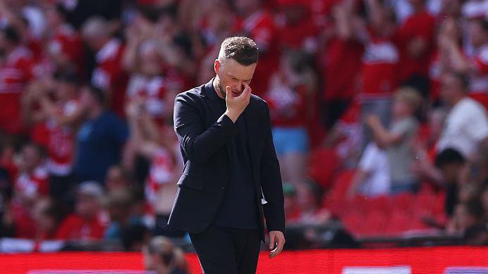 Kim Hellberg looking down at the floor, while scratching his face with his right hand at Wembley  