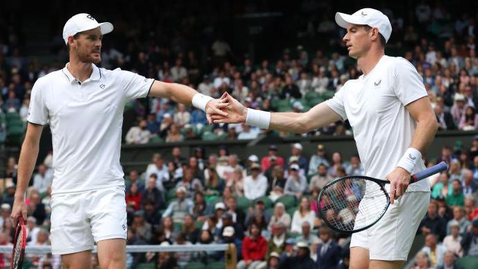 Jamie and Andy Murray touch hands