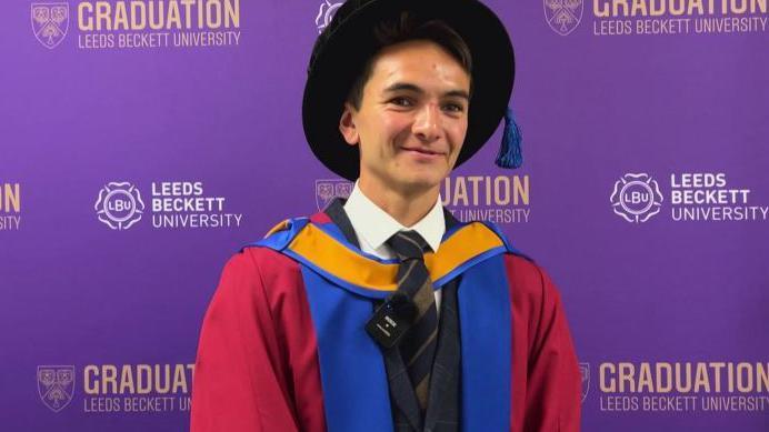 Alex Yee, world champion triathlete, in a cap and gown in front of a purple background.