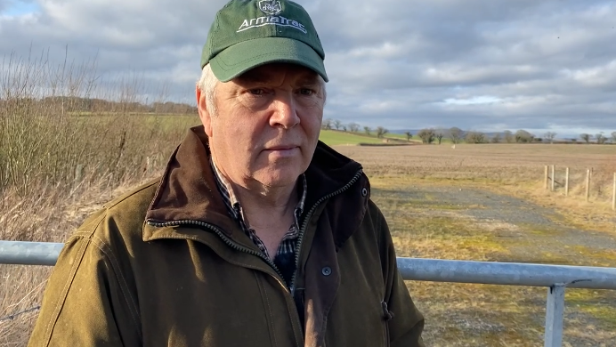 Farmer Peter Hogg standing by a gate 