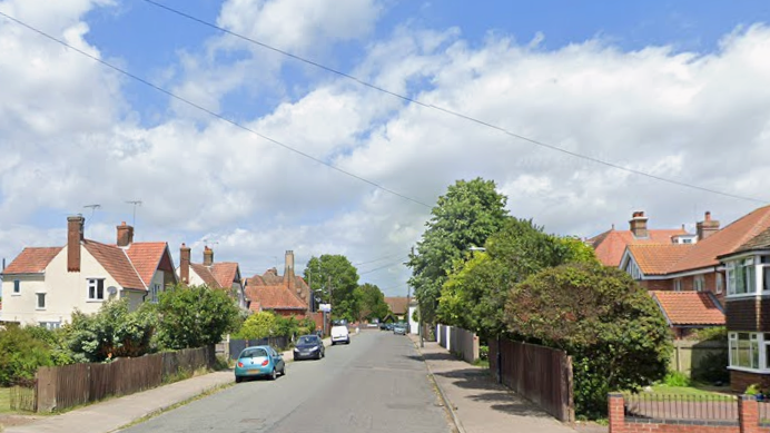 A general view of Church Road in Felixstowe. The road is lined by houses with red roofs. Some cars are parked on the left hand side of the road.