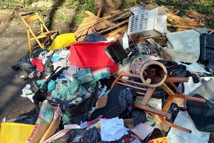 A heap of rubbish including furniture by a roadside