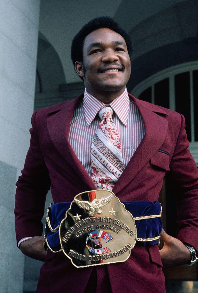 Foreman smiling and wearing his heavyweight champion belt