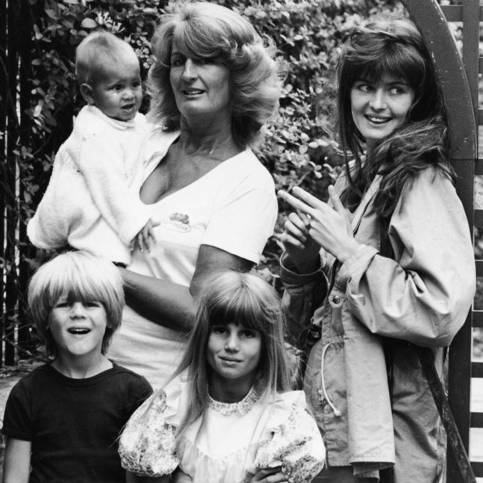 A black and white photo from 1981 of Lady Annabel with a baby in her arms, two small children standing in front of her and an young woman by her side.