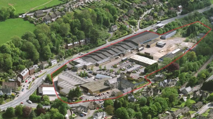 An aerial shot of the site of the Brimscombe Port development in Stroud, which has a red ring drawn around it. It is in a valley with a main road to one side and is surrounded by trees and houses.