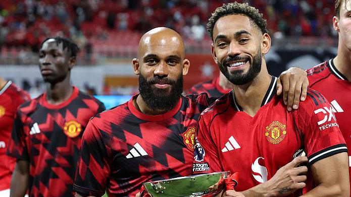 Bryan Mbeumo, left, and Matheus Cunha holding a trophy