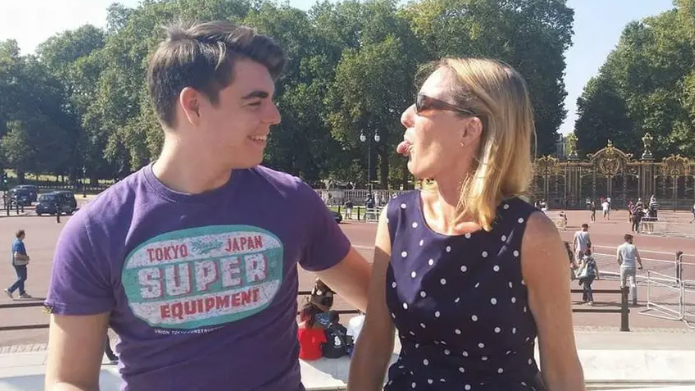 Oliver McGowan with his mum. They are looking at each other and she has her tongue sticking out, while he is smiling. They are standing outside in the sunshine.