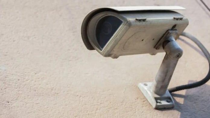 Shows a security camera on a wall