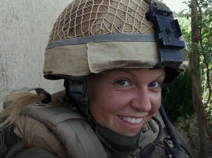 Hayley Lawrence smiles at the camera wearing a military helmet