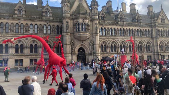 The giraffes perform in front of a large crowd at City Park in Bradford