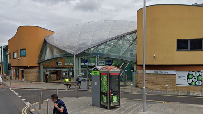 A phone box and a cash point outside a bus station
