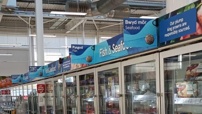 Arwyddion Cymraeg mewn Tesco yn Helston