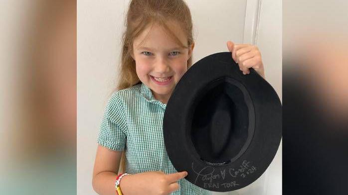 Evie Firth holding Taylor Swift's hat