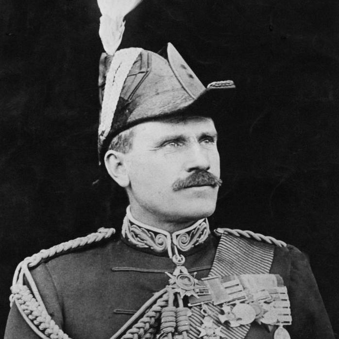 The black and white photograph shows Sir Hector wearing a ceremonial military uniform and hat. There are medals pinned to his chest. Sir Hector is looking away from the camera.