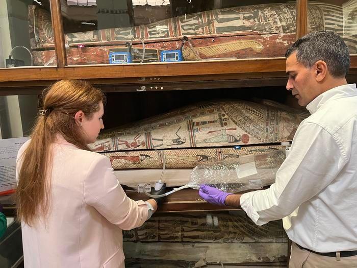 Researchers looking at mummies. 