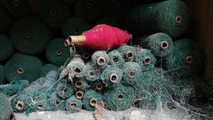 Hen rîliau edafedd coch a gwyrdd gyda gwe pry cop drostynt