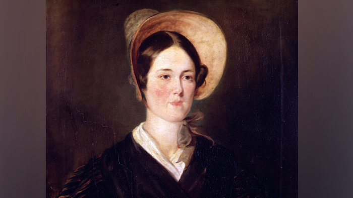 A painting portrait of Grace Darling who is pictured wearing a orange bonnet.
