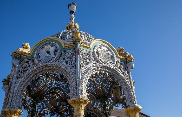 The top of the Coronation Fountain showing ornate detail on its metal arches and canopy.