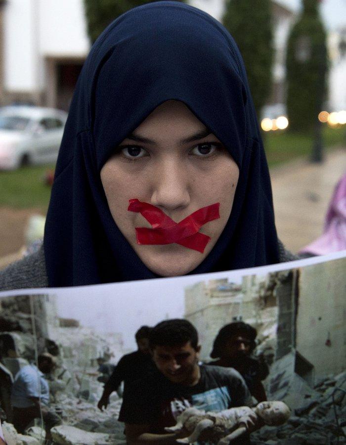 A Moroccan youth holds a picture during a demonstration in solidarity with the inhabitants of the embattled Syrian city of Aleppo on December 14, 2016 outside the parliament in the capital Rabat