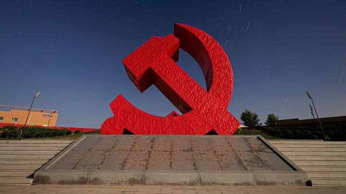 A sculpture of the Chinese Communist Party logo - a hammer and sickle in red.  