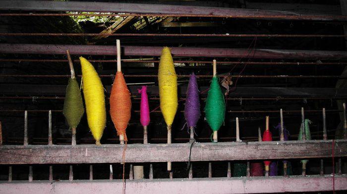 Edafedd liwgar ar bigau'r peiriant gwehyddu