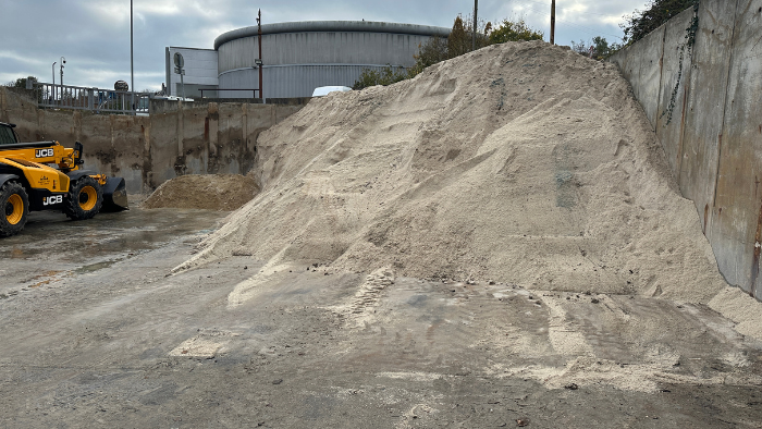 A huge pile of grit with a yellow JCB gritter in site