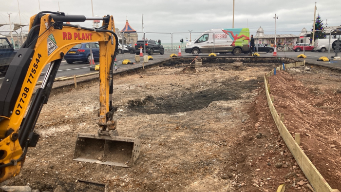 A yellow digger being used to remove a traffic island near the Palace Pier in Brighton.