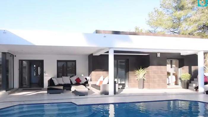A villa where there is a swimming poor and outdoor seating area.