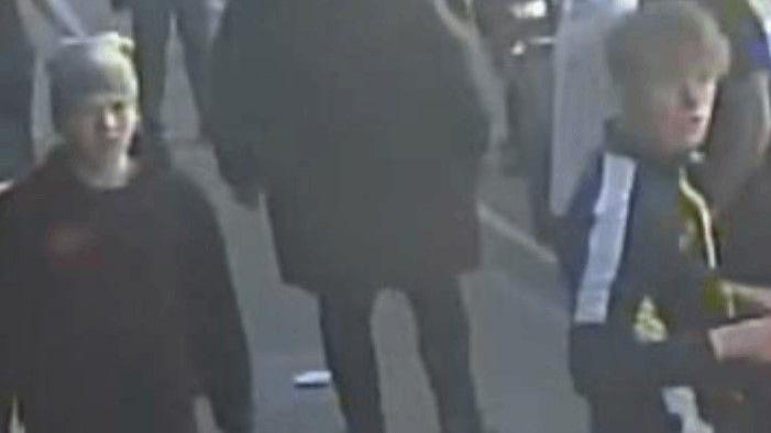 Two young males captured on blurry CCTV image walking down a street.