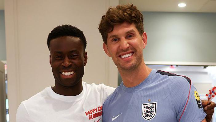 A picture of Guehi and Stones smiling at the camera at England's training camp in Kansas City
