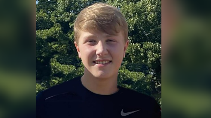 Matthew Daulby smiling at the camera, wearing a black Nike t-shirt, he has blonde short hair and light eyes.