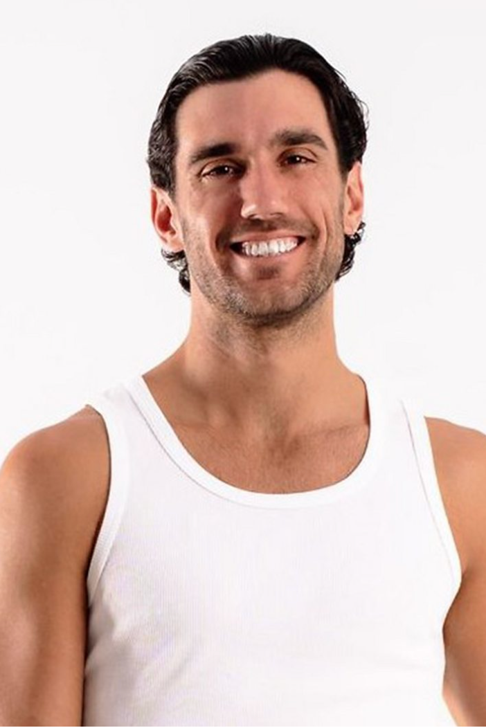 Headshot of Julian wearing a white top and posing in front of the white background