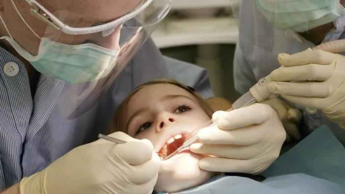 A child having their teeth looked at