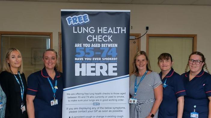 Nurses and staff at South Tyneside and Sunderland NHS Foundation Trust standing next to a banner advertising free lung health checks for those aged between 55 and 74.