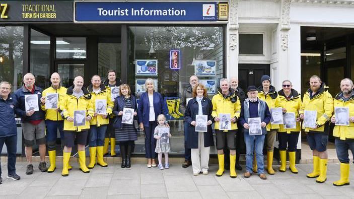 Exmouth RNLI coxswain representatives by one of the welly murals